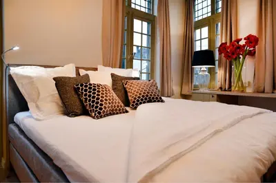 a bedroom with a large white bed with pillows at Rooms With A View in Ghent