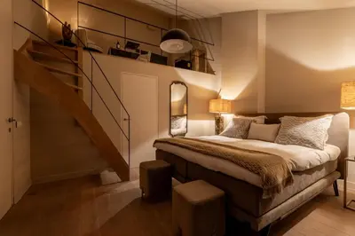 a bedroom with a large bed and a staircase at Rooms With A View in Ghent