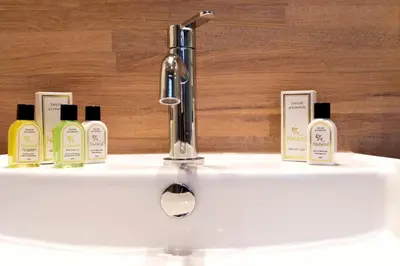 a sink with four bottles of soap and a faucet at Rooms With A View in Ghent