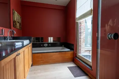 a bathroom with a bath tub and red walls at Rooms With A View in Ghent