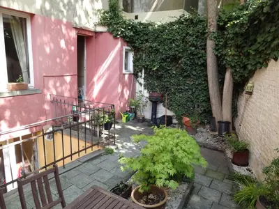 a pink house with a balcony with plants at Brugman in Brussels