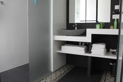 a bathroom with a sink and a shelf with towels at Logies Tommenmolen in Grimbergen