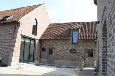 a brick building with a brown roof at Logies Tommenmolen in Grimbergen