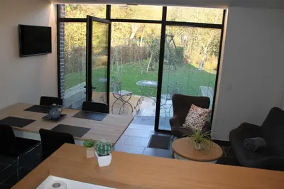a living room with two tables and a large window at Logies Tommenmolen in Grimbergen