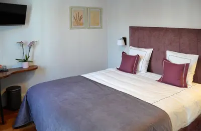 a bedroom with a large bed with purple pillows at Notarishuis Beveren B&B in Beveren
