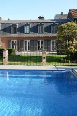 a large blue swimming pool in front of a house at Notarishuis Beveren B&B in Beveren