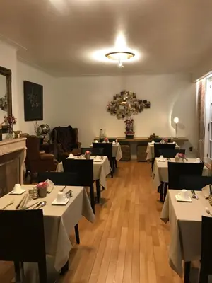 a dining room with white tables and black chairs at Notarishuis Beveren B&B in Beveren
