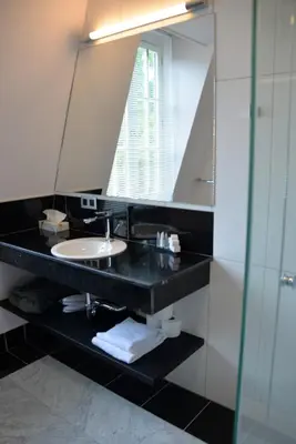 a bathroom with a sink and a mirror at Notarishuis Beveren B&B in Beveren