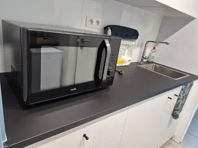 a microwave sitting on a counter next to a sink at Dokstudio50 in Ghent