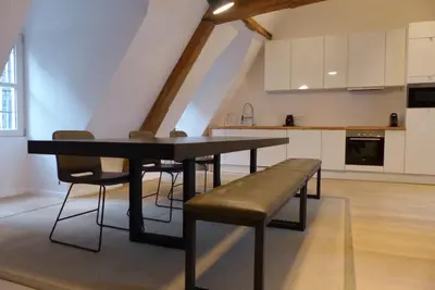 a kitchen with a table and a bench in a room at Living The Dream in Ghent