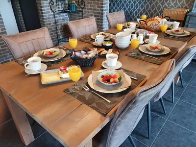 a long wooden table with plates of food on it at B&B de Rijcke Rust in Rijkevorsel