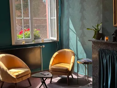 a living room with two chairs and a window at Flandria Hotel Gent Centrum in Ghent