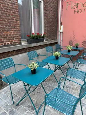 a row of blue tables and chairs on a patio at Flandria Hotel Gent Centrum in Ghent