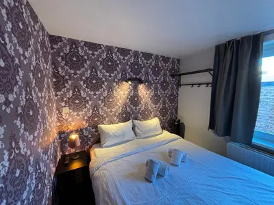 a bedroom with a bed with lights on the wall at Flandria Hotel Gent Centrum in Ghent