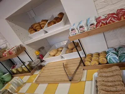 a bakery with shelves of bread and other baked goods at Flandria Hotel Gent Centrum in Ghent