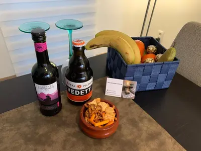 a bottle of beer and a bowl of nuts and a basket of fruit at BnB Antwerp Centrum in Antwerp