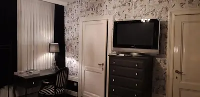 a room with a television on a dresser with a dresser at B&B Bon-Bon 'nuit' in Turnhout