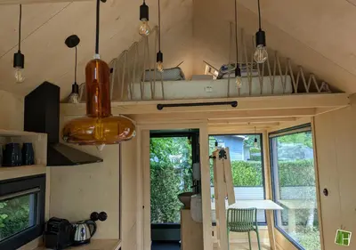 a tiny house with a kitchen and a living room at Camping Houtum in Kasterlee