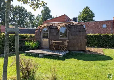 a wooden gazebo with a table in a yard at Camping Houtum in Kasterlee