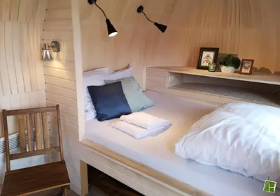 a bedroom with a white bed with a blue pillow at Camping Houtum in Kasterlee