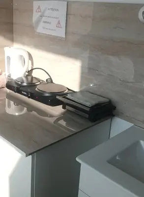 a kitchen counter with a stove with two pans on it at Private Studio Brussels Airport in Brussels