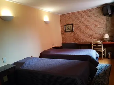 a room with two beds and a brick wall at Hotel La Barakka in Lokeren