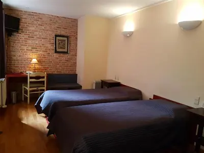 a hotel room with two beds and a desk at Hotel La Barakka in Lokeren