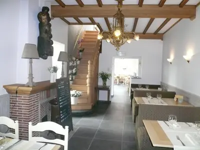 a restaurant with a dining room with a chandelier at Hotel La Barakka in Lokeren