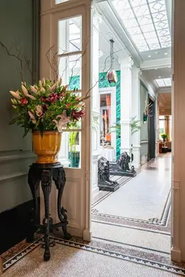 a vase of flowers on a table in a hallway at Cabosse, Boutique Palace & Spa in Antwerp