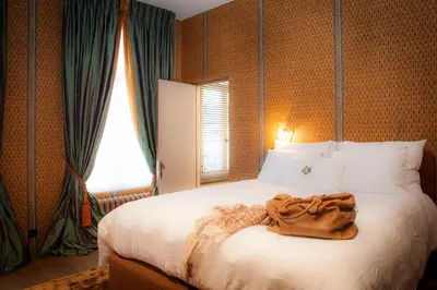 a bedroom with a bed with a blanket on it at Cabosse, Boutique Palace & Spa in Antwerp