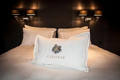 a bed with a white pillow with the word casserole at Cabosse, Boutique Palace & Spa in Antwerp