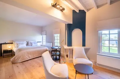 a bedroom with a bed and two chairs at B&B Sterckxhof in Meise