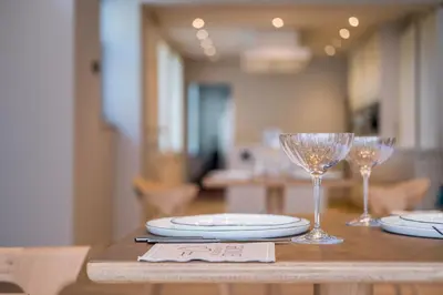 a wooden table with glasses and plates on it at B&B Sterckxhof in Meise
