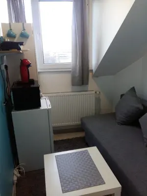 a small living room with a couch and a window at Private Studio Brussels Airport in Brussels