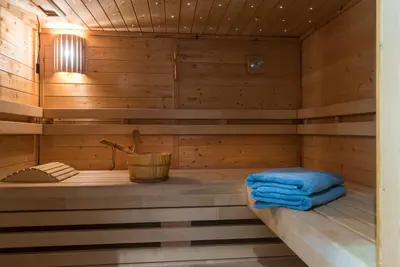 a sauna with a bench in a wooden cabin at Casa-Cosi, tourist & business suites & flats with reserved parking included, private sauna in Lokeren