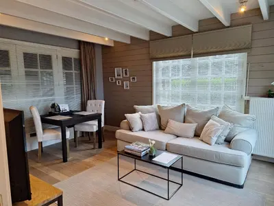 a living room with a couch and a table at Casa-Cosi, tourist & business suites & flats with reserved parking included, private sauna in Lokeren