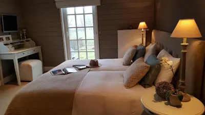a bedroom with a large white bed with a window at Casa-Cosi, tourist & business suites & flats with reserved parking included, private sauna in Lokeren