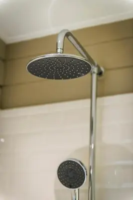 a shower with a shower head in a bathroom at Casa-Cosi, tourist & business suites & flats with reserved parking included, private sauna in Lokeren