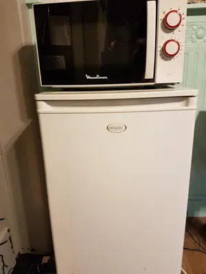 a microwave sitting on top of a refrigerator at Gastenkamers in vakantiewoning CasaCuriosa in Mol