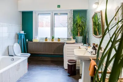 a bathroom with a tub and a toilet and a sink at Gastenkamers in vakantiewoning CasaCuriosa in Mol