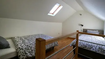 a attic bedroom with two beds and a window at B&B Handelshof in Lier