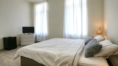 a bedroom with a large white bed and a television at B&B Handelshof in Lier