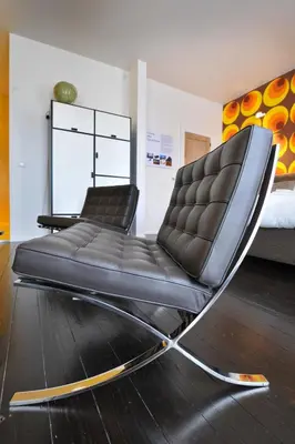 a black leather chair in a room with a bed at B&B Kava in Antwerp