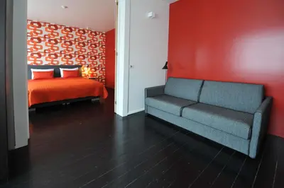 a living room with a couch and a bed at B&B Kava in Antwerp