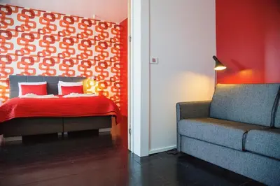 a bedroom with a bed and a couch and a chair at B&B Kava in Antwerp