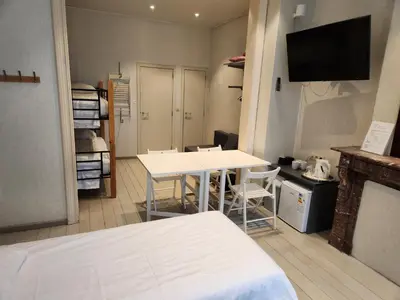 a room with a bed and a table and chairs at Albert - Rooms in Mechelen