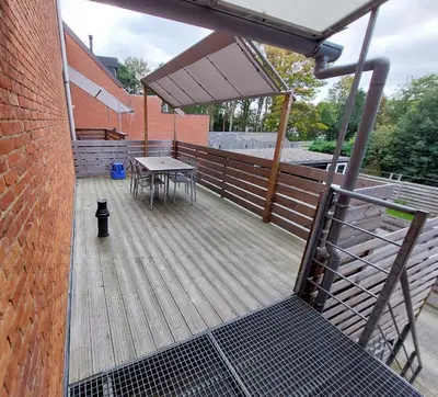 a wooden deck with a picnic table on a building at Mathilda - apartments in Grobbendonk