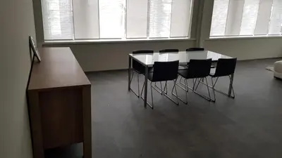 a table and chairs in a room with windows at Mathilda - apartments in Grobbendonk