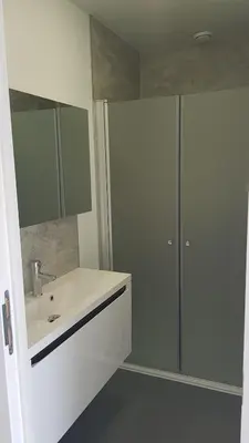 a white bathroom with a sink and a shower at Mathilda - apartments in Grobbendonk