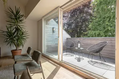 a room with a balcony with chairs and a table at Logement Den Beer in Meerhout